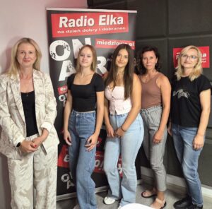 Trzy studentki pozują razem z mgr Anną Akielaszek-Witczak i mgr Katarzyną Prałat-Idzik na w radiowym studiu, za nimi baner promocyjny z napisem: Radio Elka
