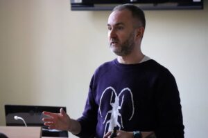 Przedstawiciel Pulse of Mind: Mindaugas Latisenka podczas spotkania z pracownikami, w auli.