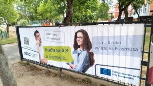 Baner reklamowy: zdjęcie studenta i studentki oraz ich rozmowa w formie dymków: Jakie plany po maturze? Odpowiedź: Studia za 0 zł w Głogowie, a na II roku wyjazd na Erasmusa. W lewym dolnym rogu Logotyp PANS w Głogowie, w prawym dolnym rogu Logotyp z flagą UE z informacją o dofinansowaniu przez Unię Europejską.