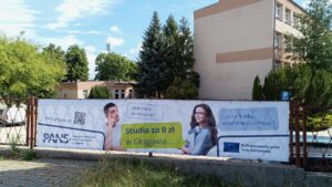 Baner reklamowy: zdjęcie studenta i studentki oraz ich rozmowa w formie dymków: Jakie plany po maturze? Odpowiedź: Studia za 0 zł w Głogowie, a na II roku wyjazd na Erasmusa. W lewym dolnym rogu Logotyp PANS w Głogowie, w prawym dolnym rogu Logotyp z flagą UE z informacją o dofinansowaniu przez Unię Europejską.