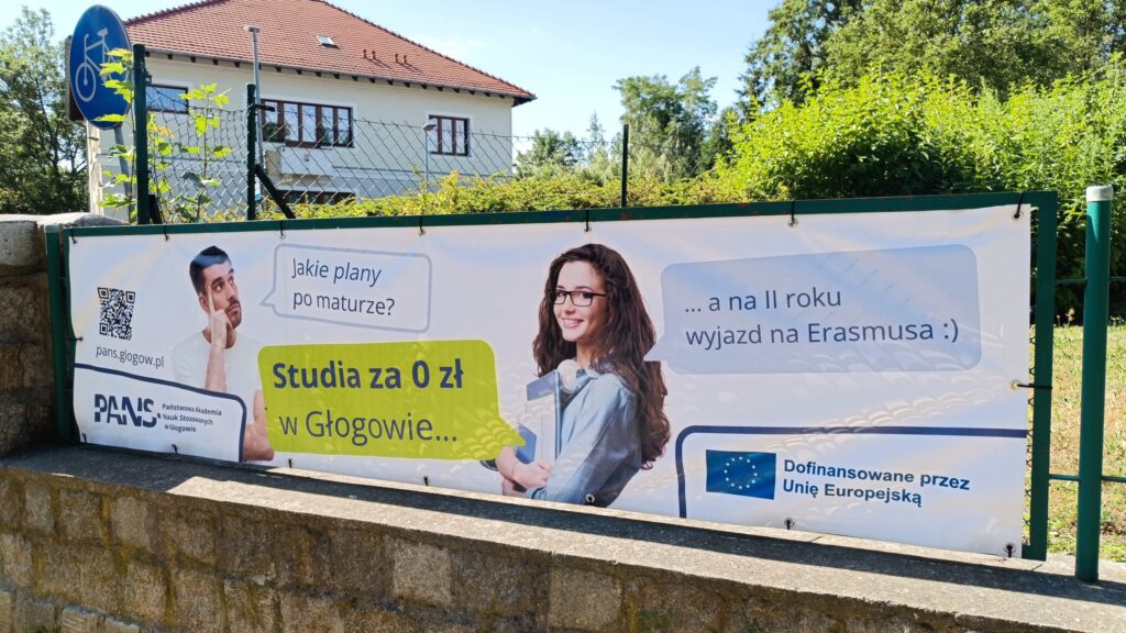 Baner reklamowy: zdjęcie studenta i studentki oraz ich rozmowa w formie dymków: Jakie plany po maturze? Odpowiedź: Studia za 0 zł w Głogowie, a na II roku wyjazd na Erasmusa. W lewym dolnym rogu Logotyp PANS w Głogowie, w prawym dolnym rogu Logotyp z flagą UE z informacją o dofinansowaniu przez Unię Europejską.